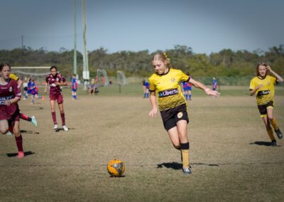 girl chasing after soccer ball