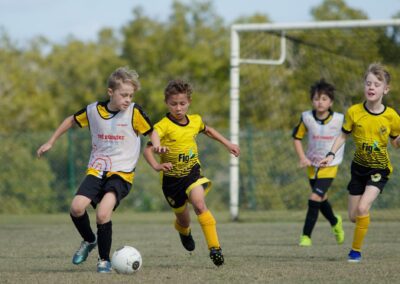 kids chasing soccer ball in front of goal